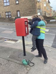 Child posting a letter in a post box.