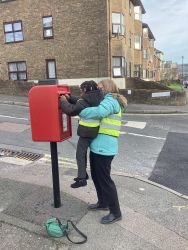 Child posting a letter in a post box.