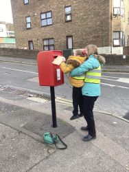 Child posting a letter in a post box.