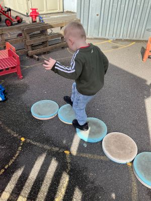Child stepping along the musical stepping stones